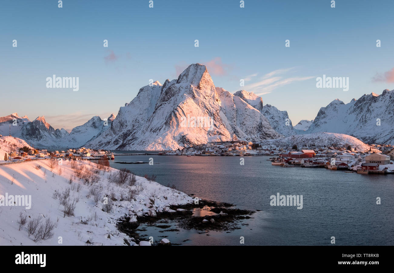 Sunrise Olstind sulla montagna innevata in inverno a Reine, Isole Lofoten in Norvegia Foto Stock