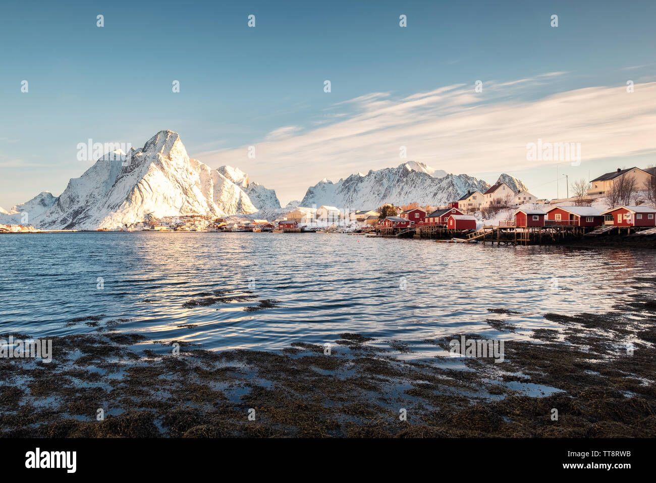 Scandinavian villaggio di pescatori con la montagna innevata a coste. Reine, isole Lofoten in Norvegia Foto Stock