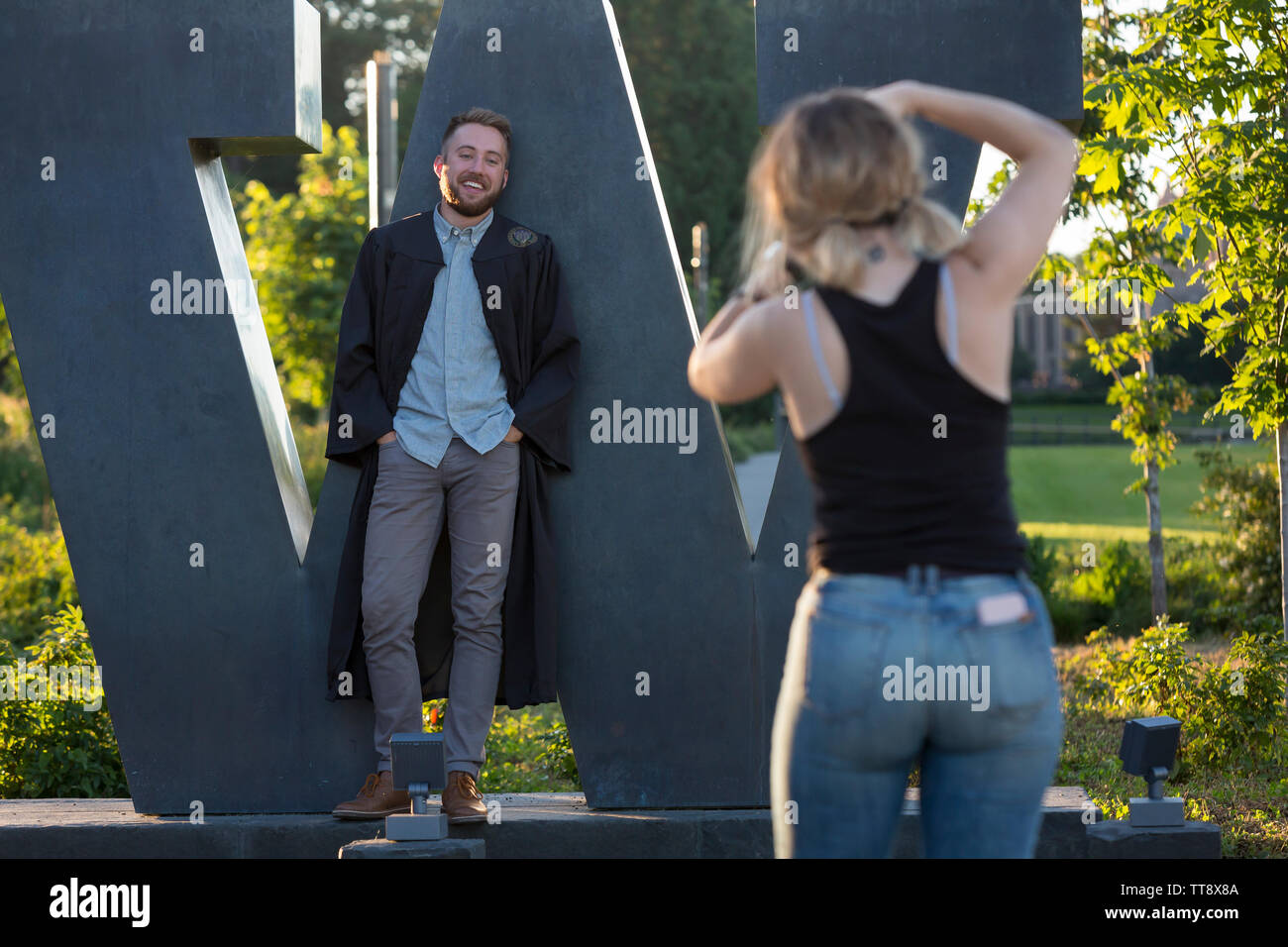 Un laureato pone per le foto al 'W' scultura lungo Boulevard Mountlake presso l Università di Washington il 11 giugno 2019. Foto Stock