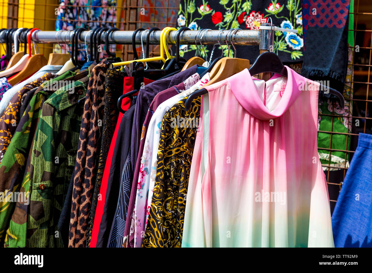 Di seconda mano vestiti su una rotaia al mercato delle pulci al cantiere di aceto, London, Regno Unito Foto Stock