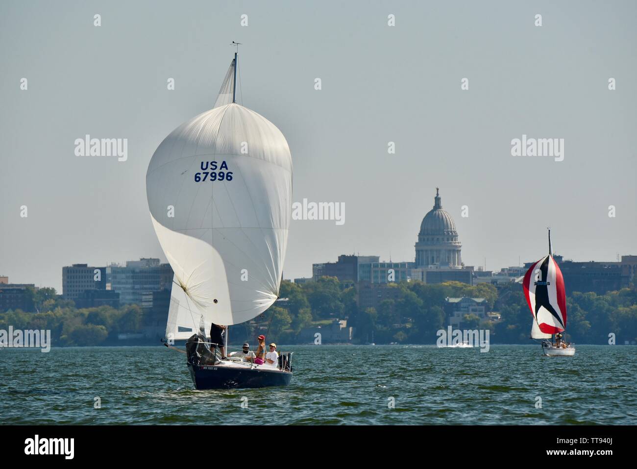 Barca a vela sul lago Mendota, con spinnaker fino a cogliere il vento, con Capitol Building in background, Madison, Wisconsin, STATI UNITI D'AMERICA Foto Stock