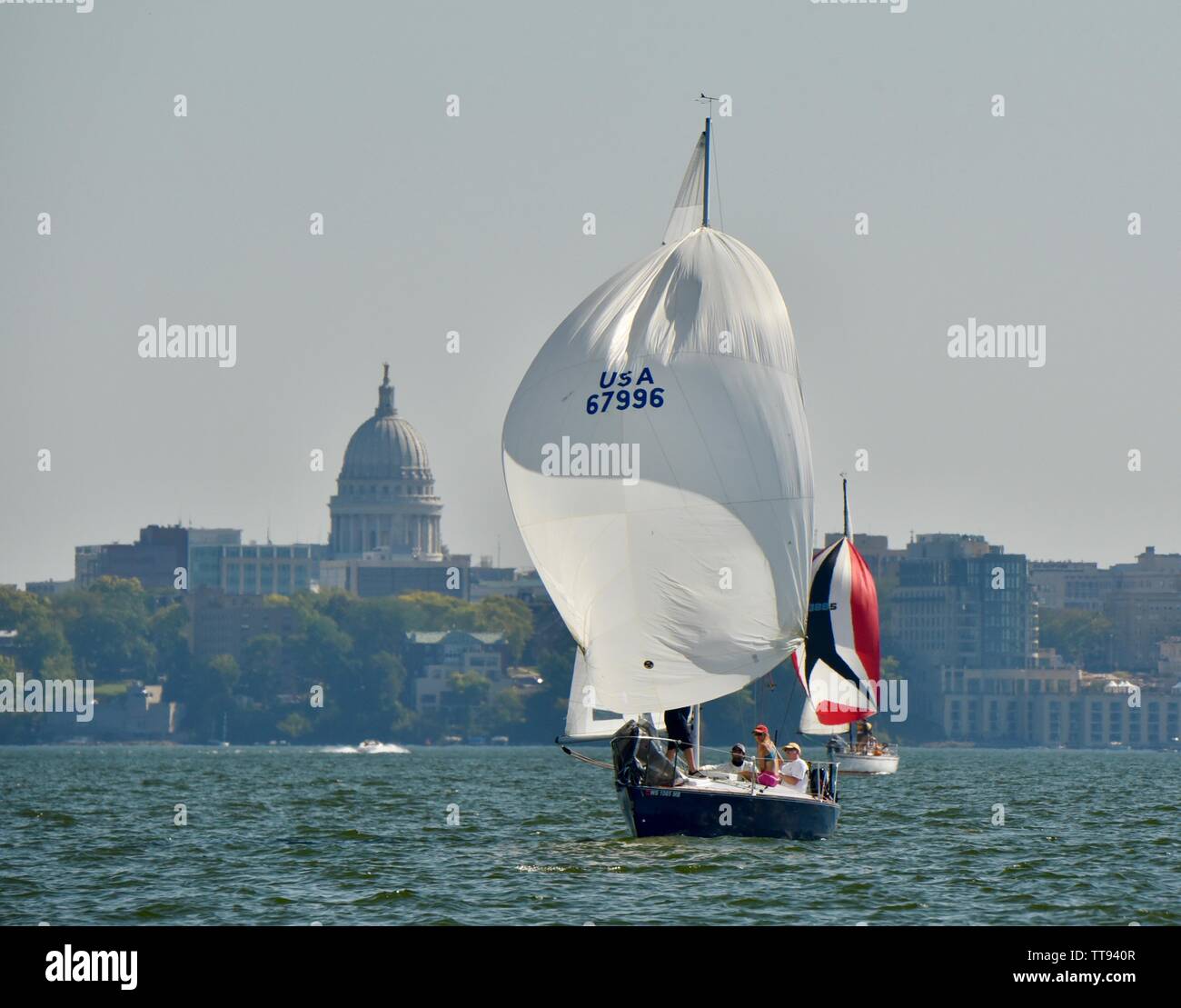 Barca a vela sul lago Mendota, con spinnaker fino a cogliere il vento, con Capitol Building in background, Madison, Wisconsin, STATI UNITI D'AMERICA Foto Stock