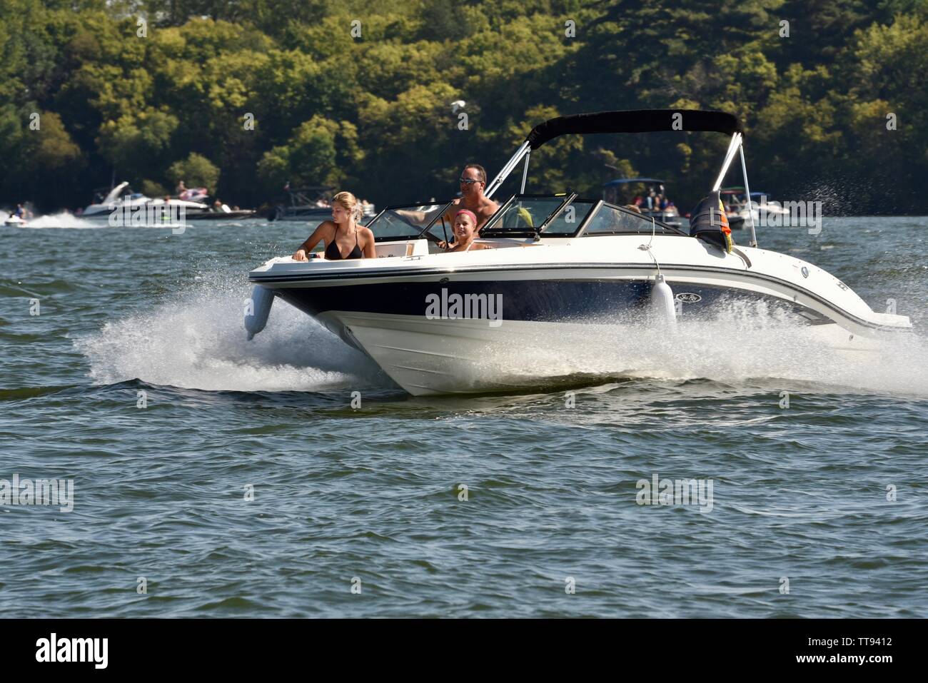 I barcaioli ricreative motoring loro imbarcazione attraverso l'acqua e facendo le onde sul lago Mendota per weekend di godimento, Madison, Wisconsin, STATI UNITI D'AMERICA Foto Stock