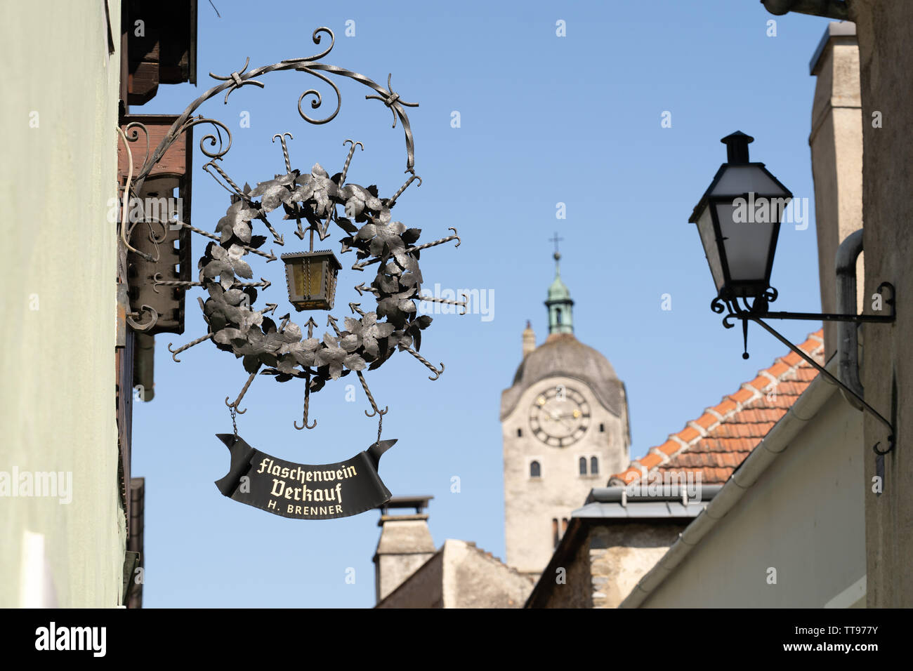 Una strada segno pubblicità un vignaiolo in Stein an der Donau, una popolare destinazione turistica, con il gotico Frauebergkirche in background Foto Stock