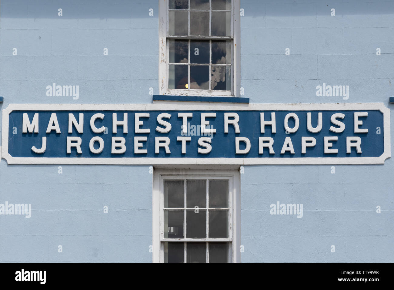 Ex Azienda Casa di Manchester J Roberts Draper shop segno su un edificio nel centro di Aberaeron, Ceredigion, Galles Foto Stock