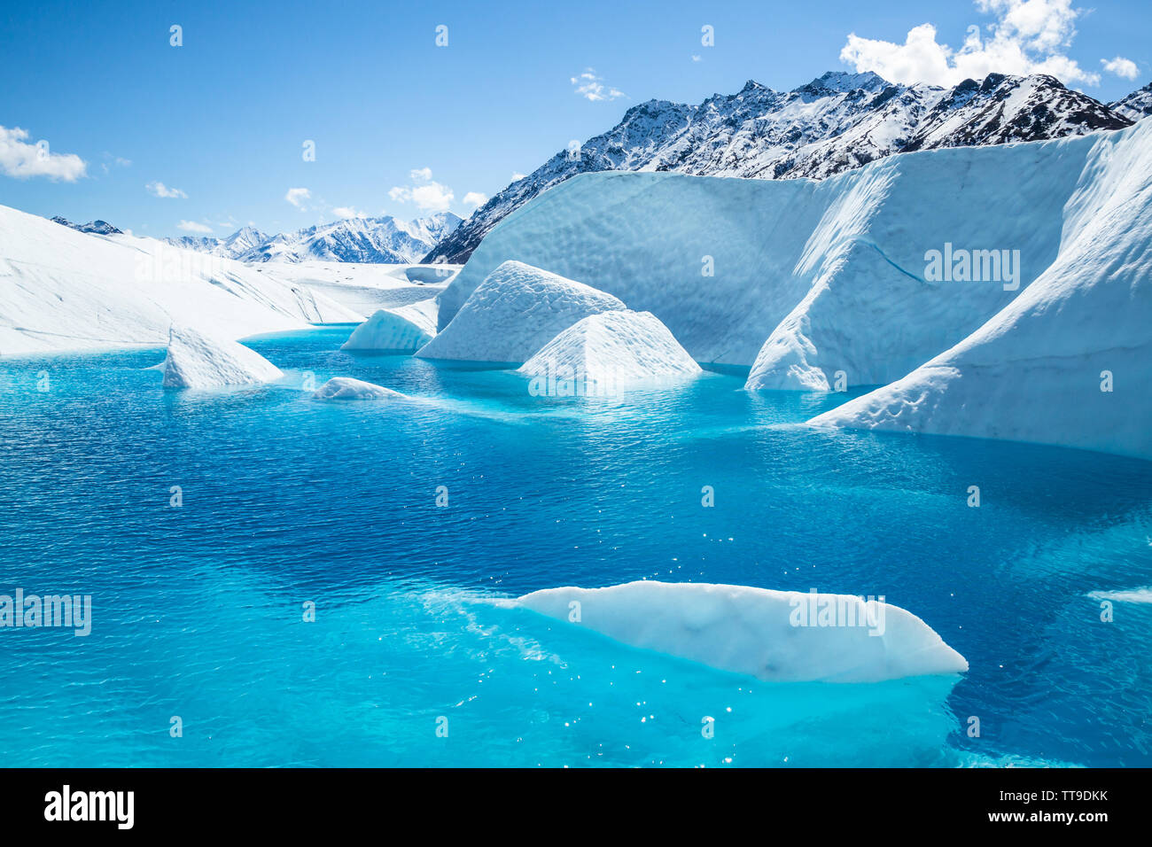 La vetta del Monte Wickersham che incombe sul ghiacciaio Matauska in Alaska. Una piscina blu cristallino si trova al di sotto del picco con alette del bianco ghiaccio spuntavano o Foto Stock