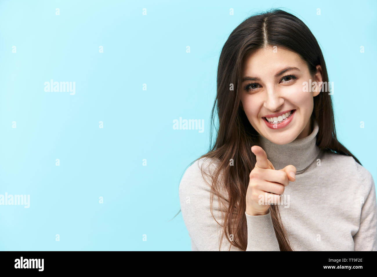 Bellissima giovane donna caucasica puntando alla fotocamera con un dito, felice e sorridente, isolato su sfondo blu Foto Stock