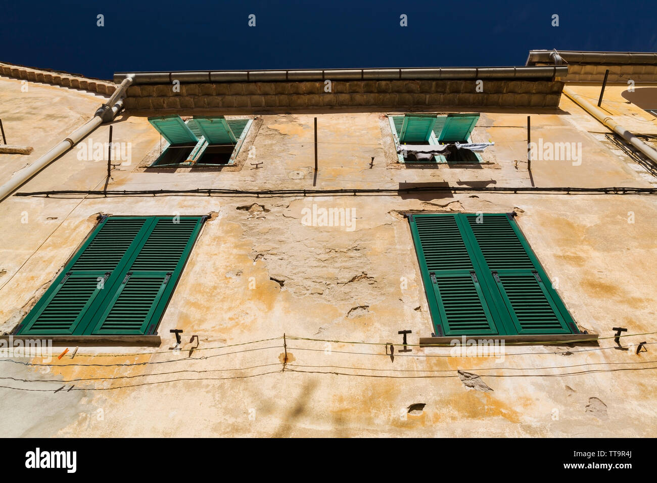 Vecchia facciata di edificio con windows ricoperta di verde a lamelle in legno scuri, Villefranche-sur-Mer, Provence, Francia Foto Stock