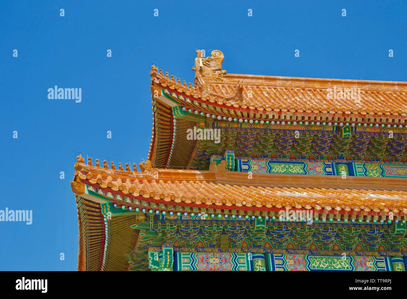 Osservando il tetto colorato di un tradizionale edificio Cinese nella Città Proibita di Pechino. Piastrelle di colore arancione con piccoli intagli della mitica anim Foto Stock