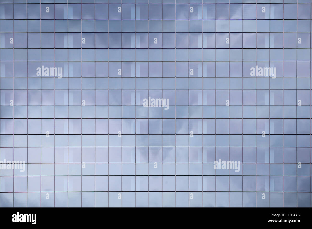 Moderno edificio di elevazione. glass curtain wall modello ripetitivo riflettendo il cloud nel cielo. gente di città nella casella architettonico. Foto Stock