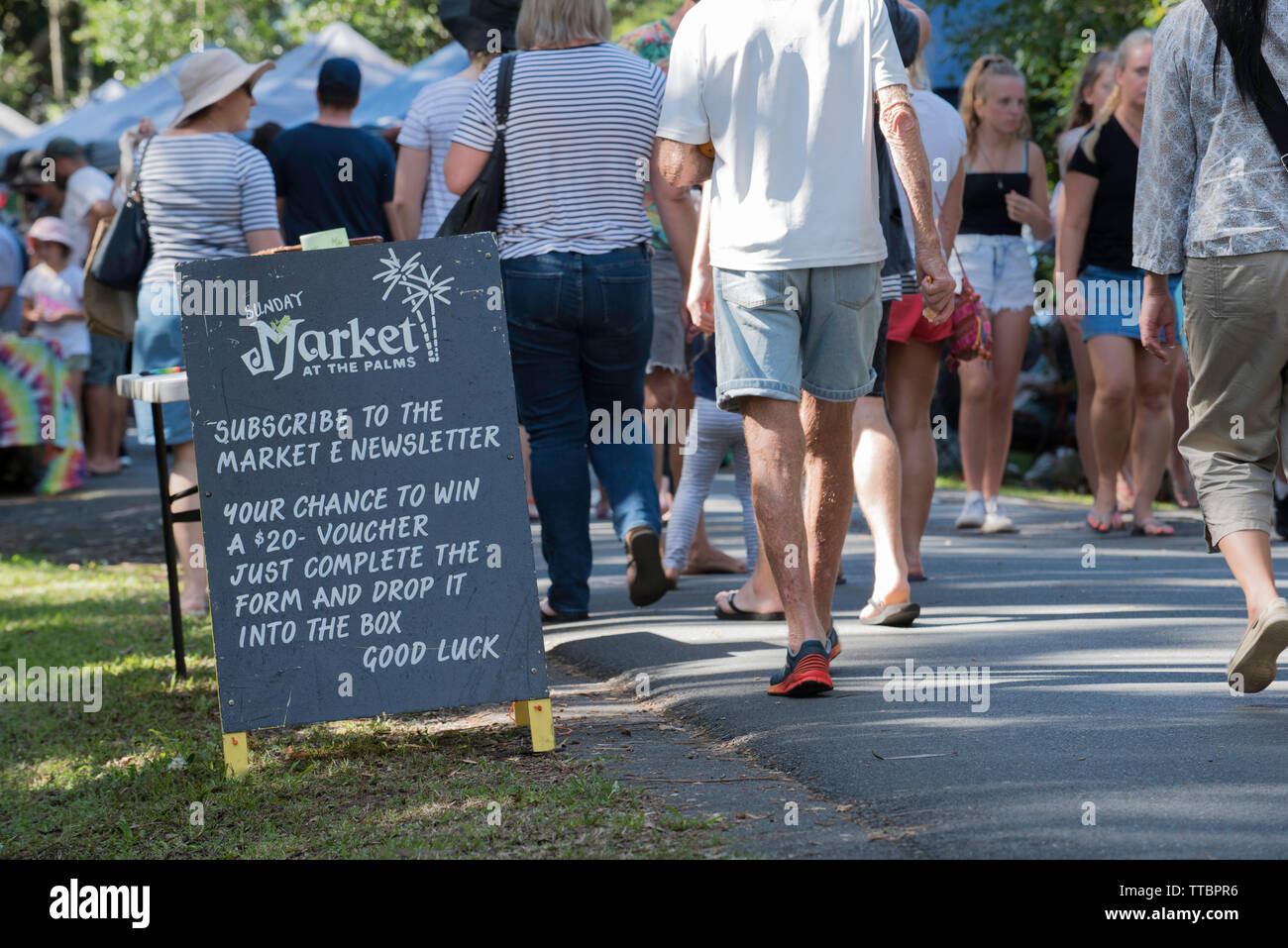 Le persone a un weekend del contadino mercato comunitario al Pacific Palms, Nuovo Galles del Sud, Australia con un segno di benvenuto Foto Stock