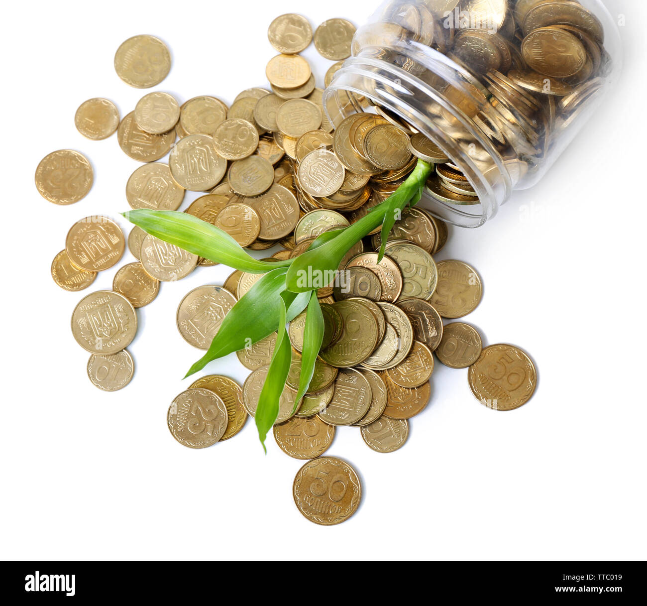Pianta che cresce in monete sparse dalla bottiglia Foto Stock