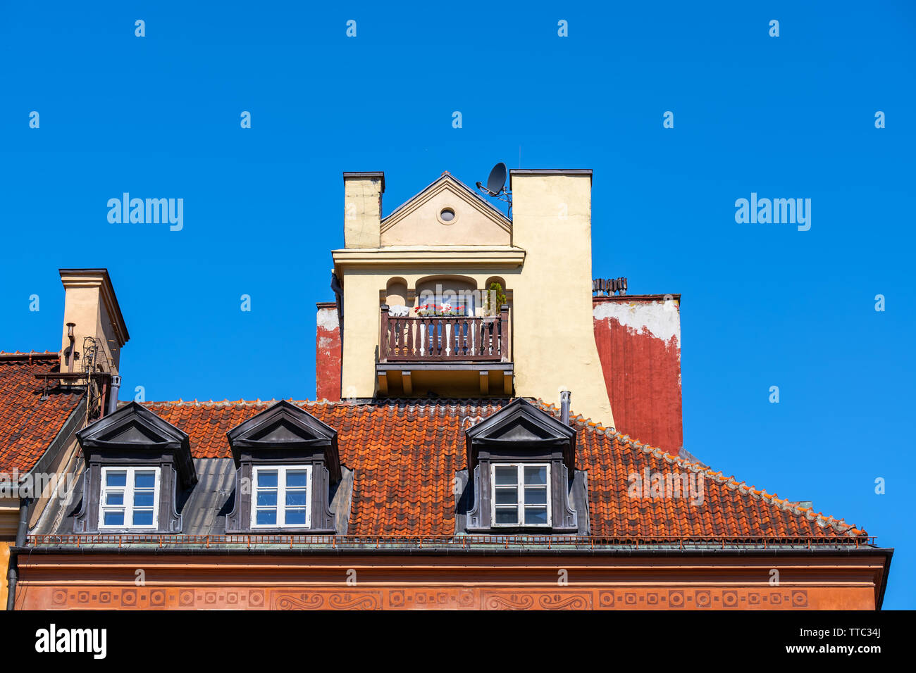Storico tradizionale tenement house attico esterno isolato contro il cielo blu, uno con piccolo balcone, windows nel tetto di tegole rosse e nella Città Vecchia di Varsavia Foto Stock