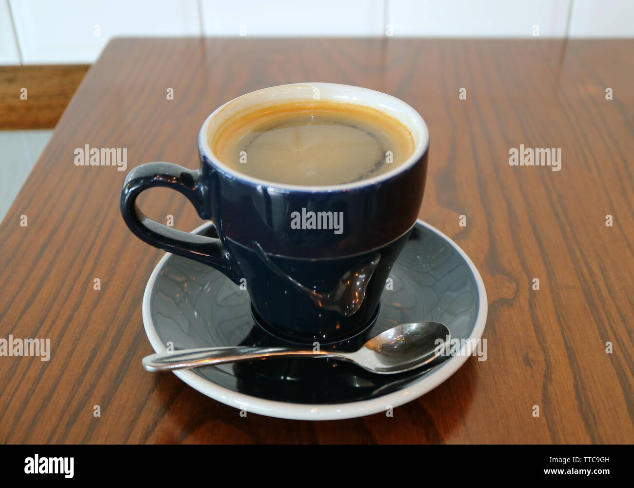 Una tazza calda di caffè Americano isolato su un tavolo di legno Foto Stock