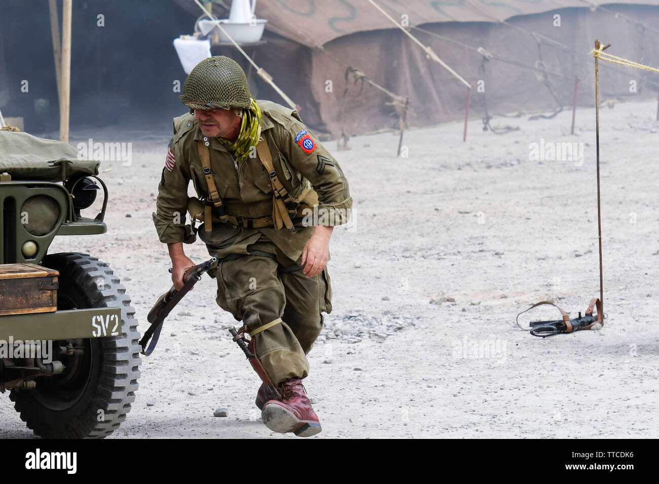 Reenactor vestito come un soldato dell'esercito statunitense ottantaduesima Airborne "tutti Americani" in esecuzione Foto Stock