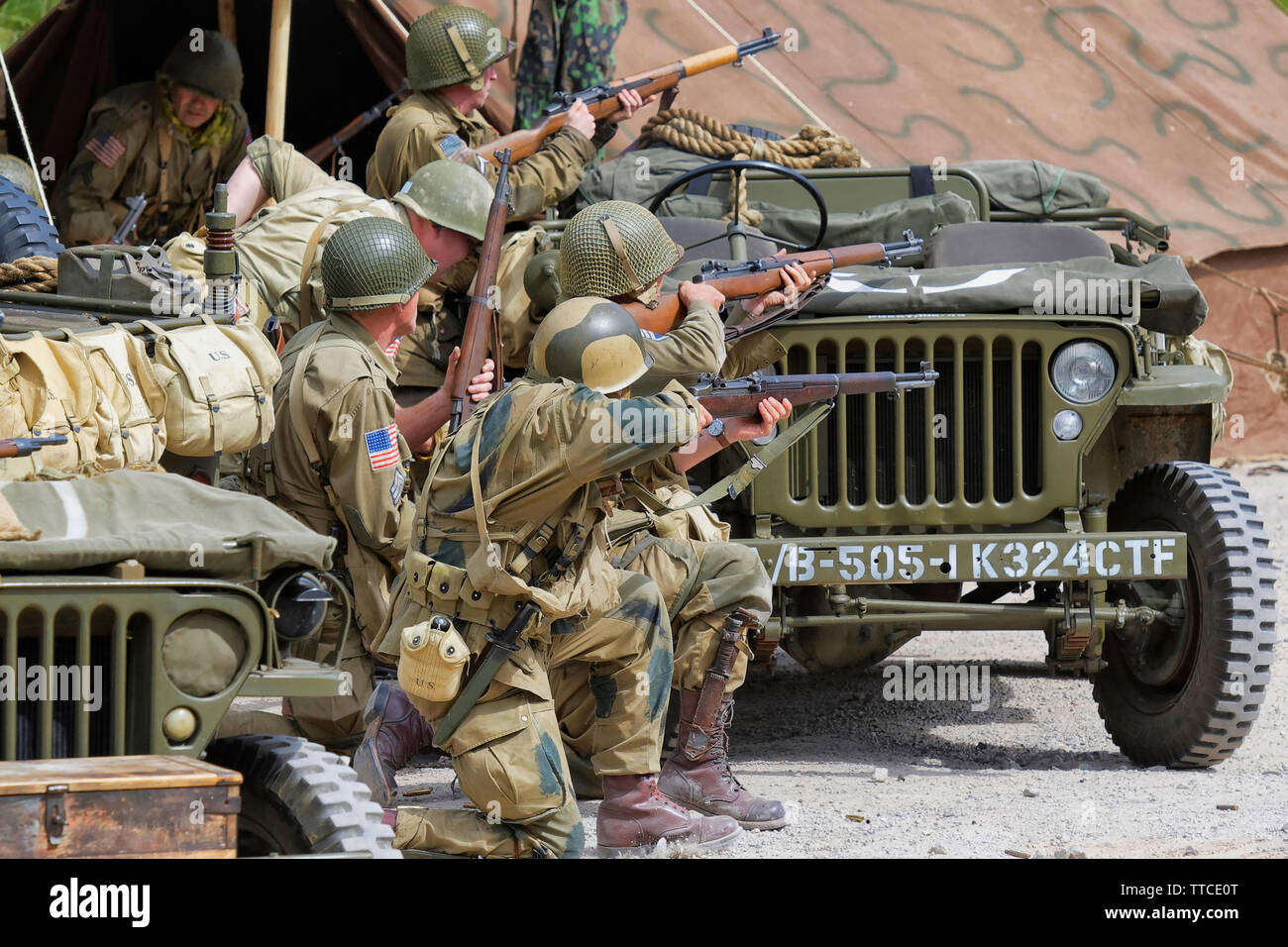 Sei Reenactors vestiti come soldati dell'esercito statunitense ottantaduesima Airborne "tutti Americani" sparando Riffles Foto Stock