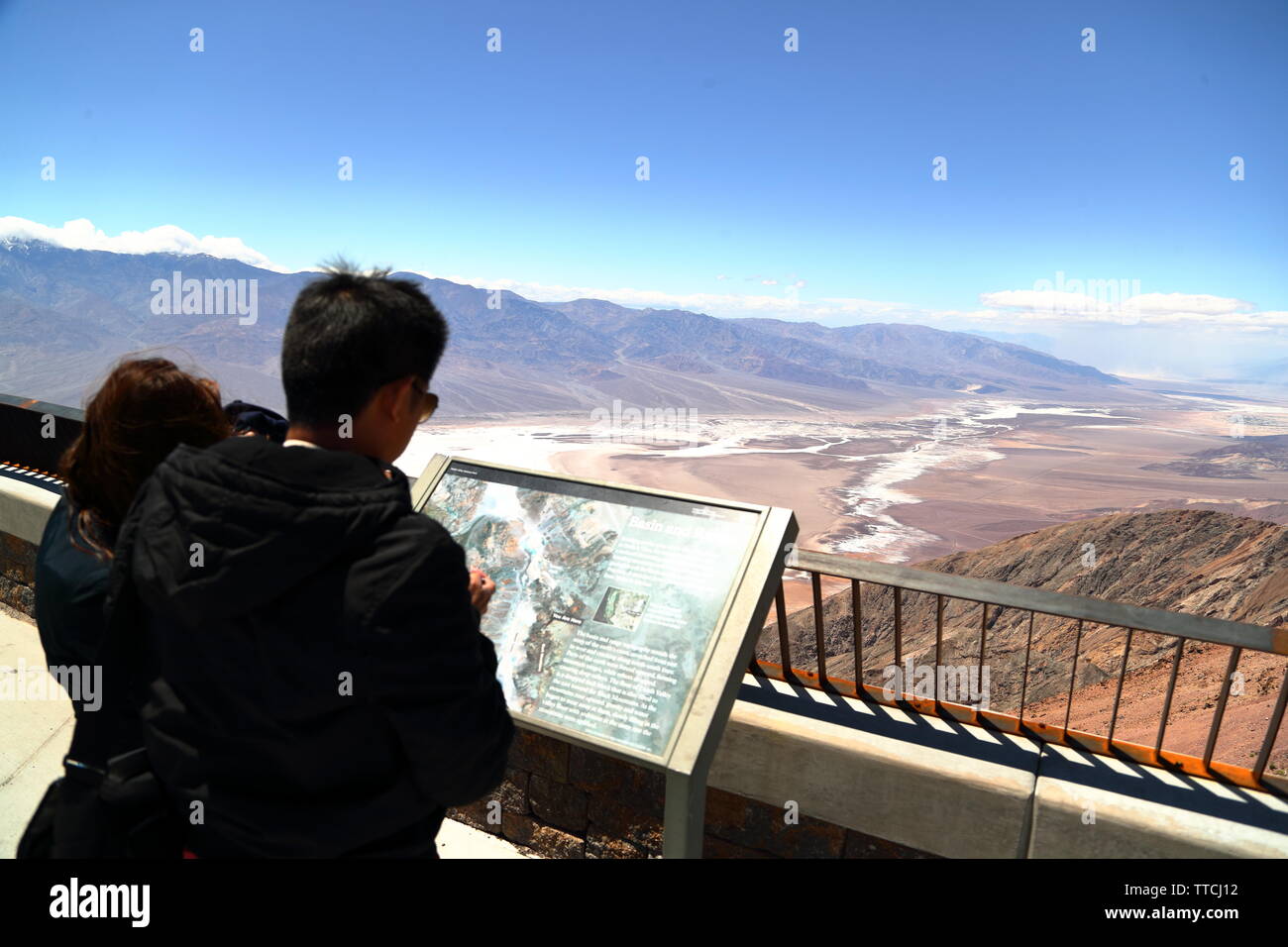 I turisti a studiare una mappa della Valle della Morte a Zabriskie Point, California, Stati Uniti d'America Foto Stock