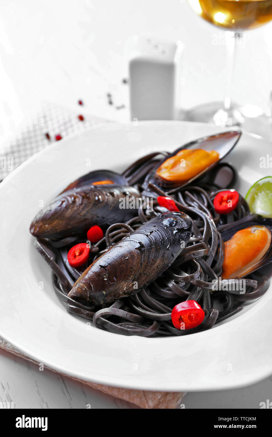 La pasta cotta, le cozze, calce e vino sulla tavola, close-up Foto Stock