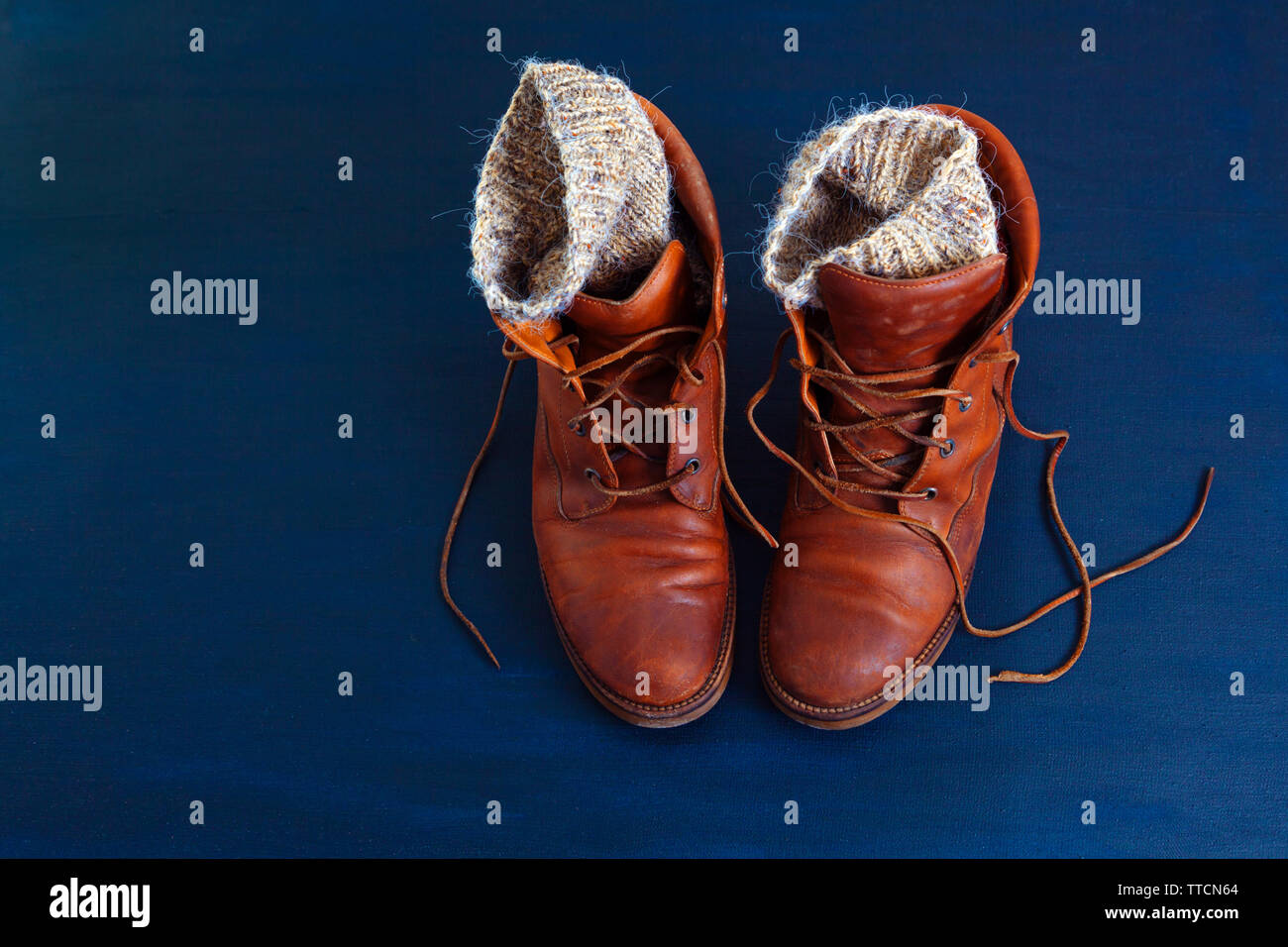 Vecchio rosso sporco scarpe alte su sfondo blu. Vecchia scuola vintage  indossato scarpe con lacci in cuoio e maglia di lana warm grey calzini Foto  stock - Alamy