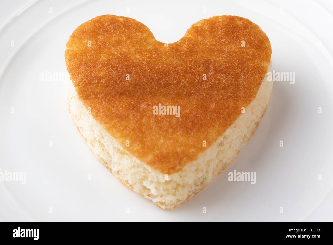I cookie con un nitido a forma di cuore su una piastra bianca. Il giorno di San Valentino e il concetto di matrimonio Foto Stock