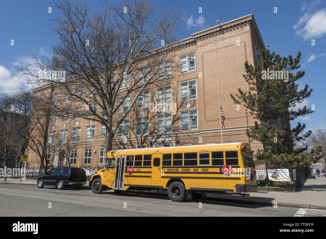 Scuola bus parcheggiato al di fuori di una New York City pubblica Scuola elementare a Brooklyn, New York. Foto Stock