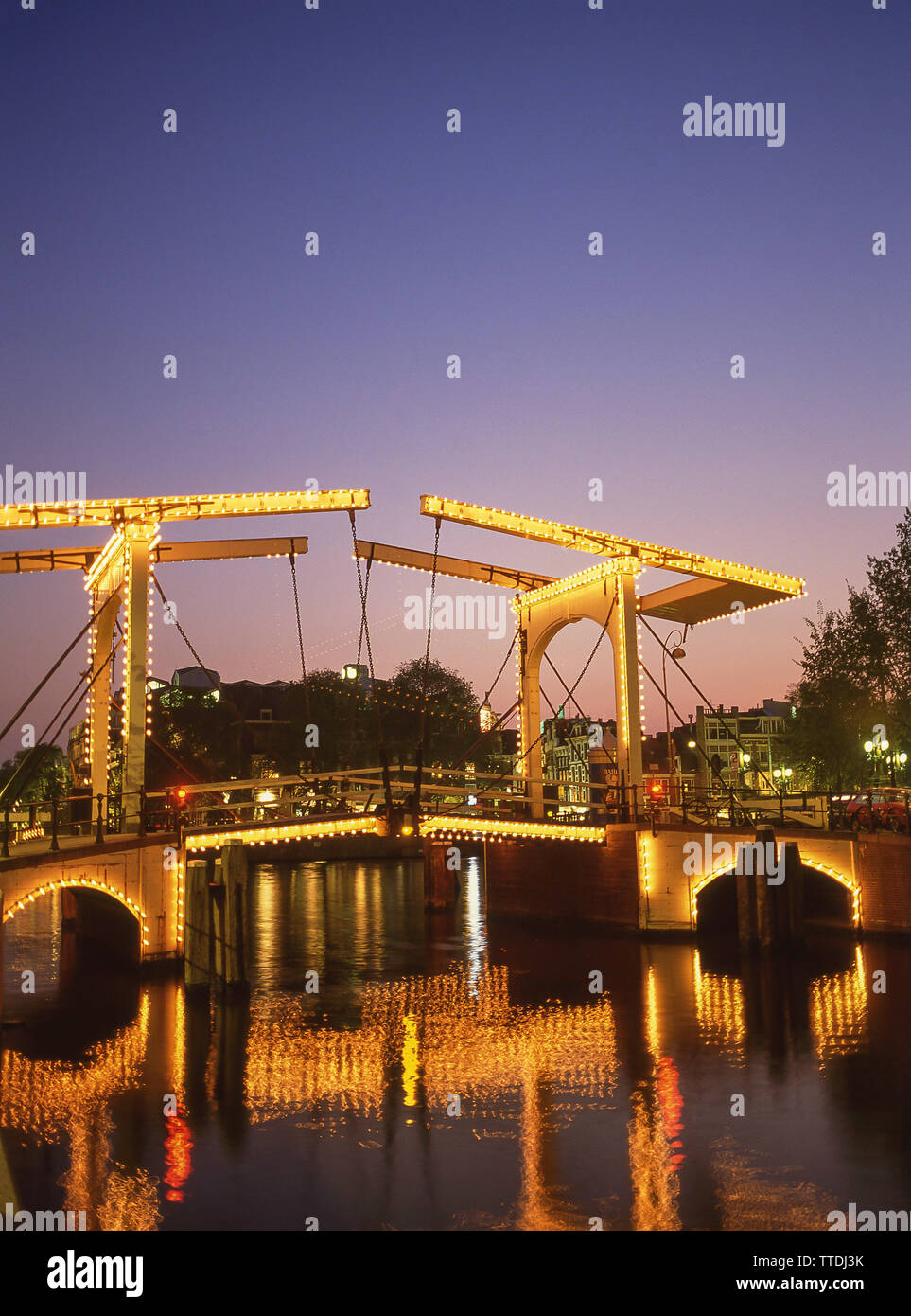 Il Magere Brug (skinny bridge) al tramonto e il fiume Amstel Amsterdam, Noord-Holland, il Regno dei Paesi Bassi Foto Stock