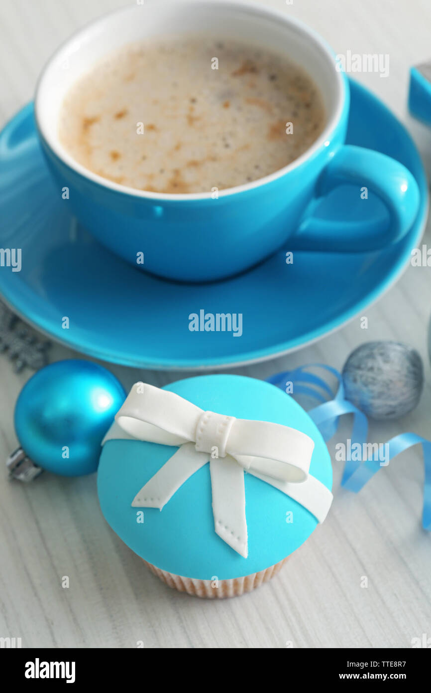 Una gustosa tortina con archetto, tazza di caffè e giocattoli di Natale sul colore di sfondo in legno Foto Stock
