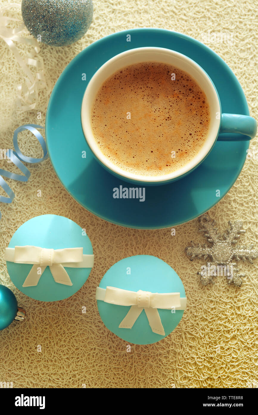 Gustosi tortini con archetto, tazza di caffè e giocattoli di Natale sul colore di sfondo in legno Foto Stock