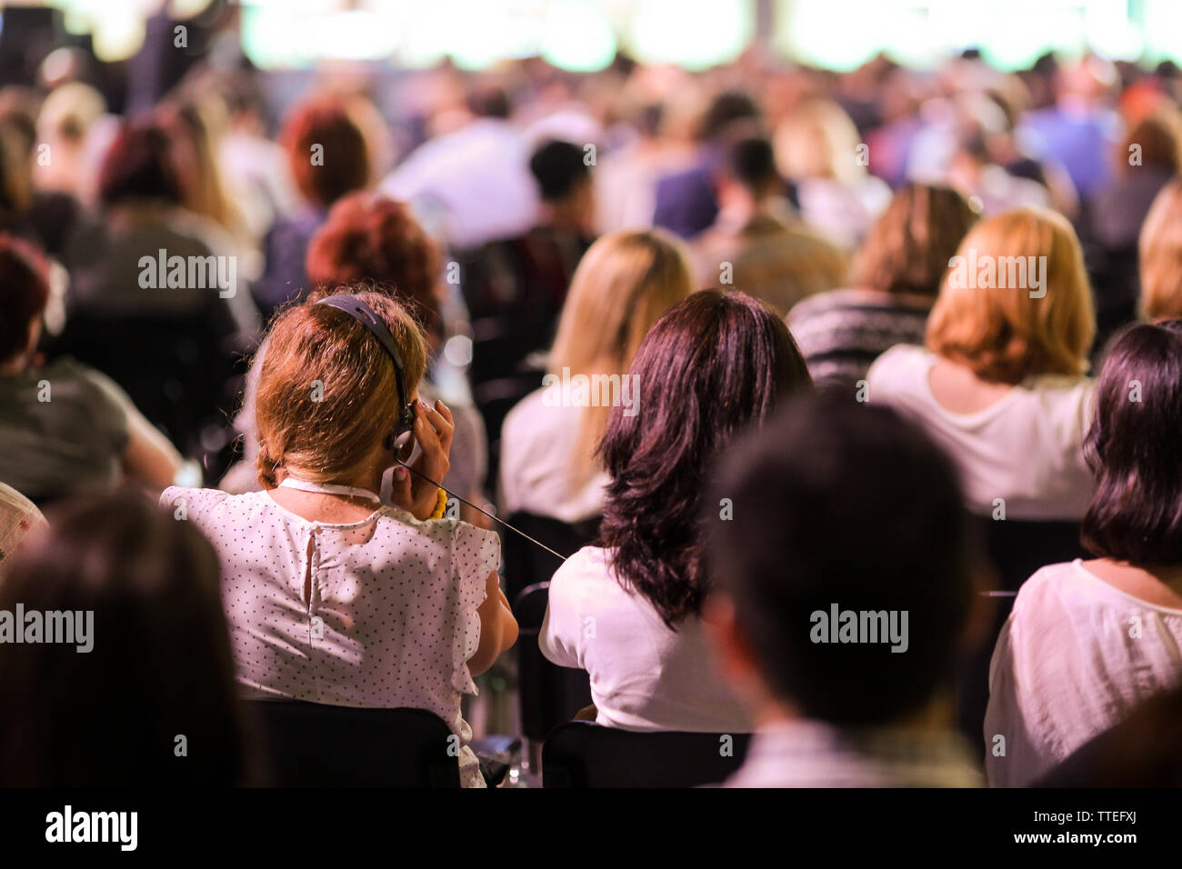 Persone partecipano a una conferenza in un grande salone. Foto Stock