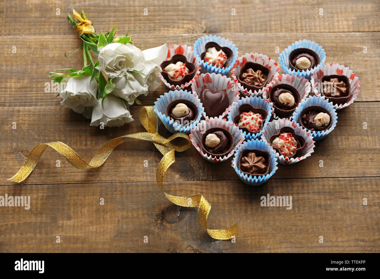 Set di cioccolatini cuore di formatura su un sfondo di legno Foto Stock