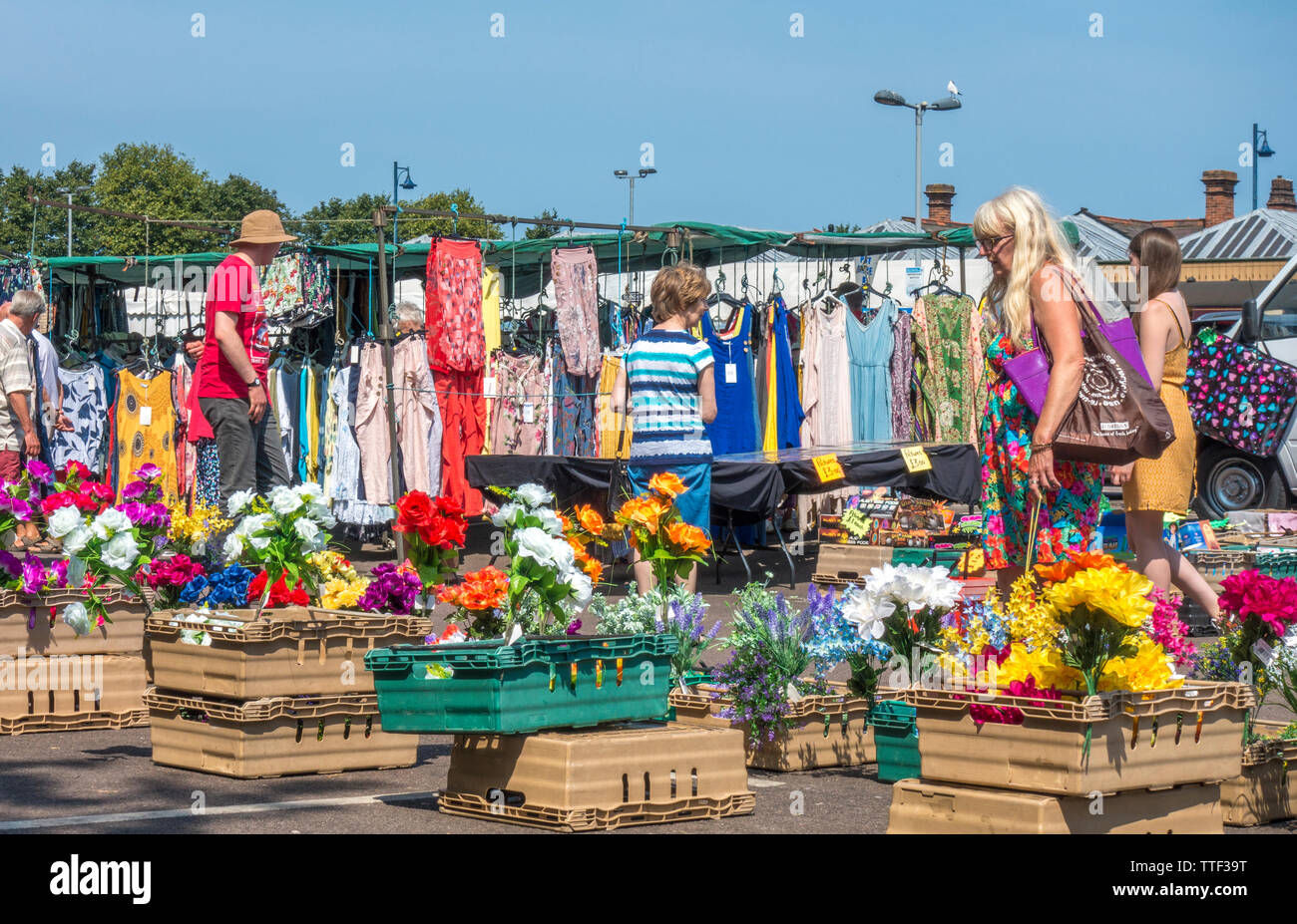 In una calda giornata estiva, persone navigando in un mercato all'aperto contro un cielo blu chiaro, in Sheringham, Norfolk, Inghilterra, Regno Unito. Foto Stock