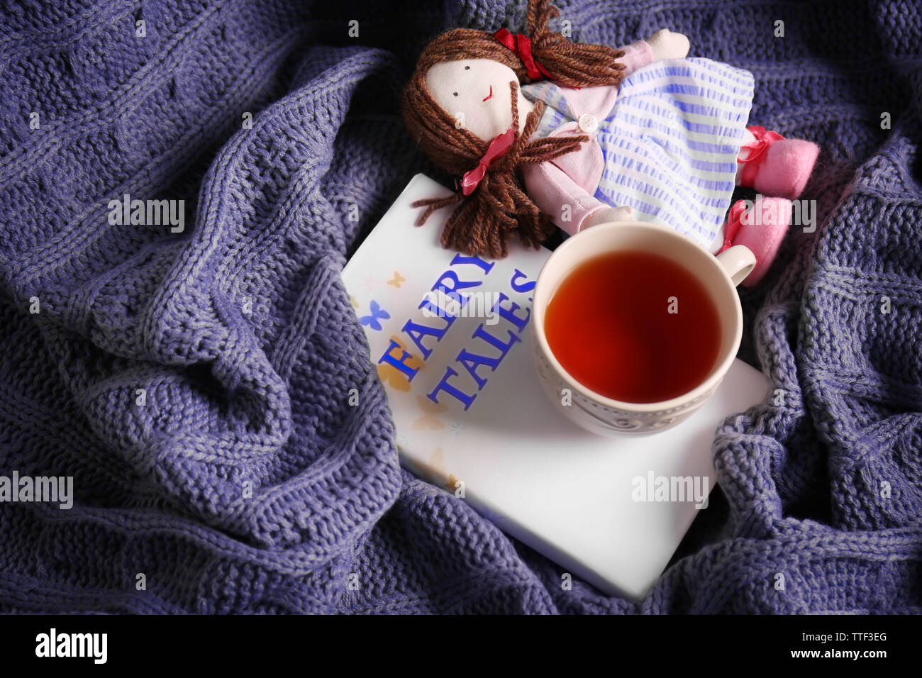 Rag Doll con favole prenota e la tazza di tè su copriletto. Concetto di infanzia Foto Stock