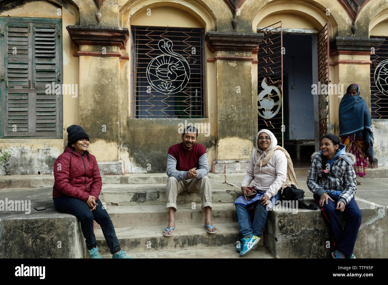 Una famiglia indiana è appeso in un inverno mattina davanti a una vecchia casa. Foto Stock