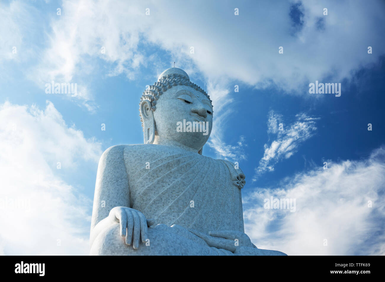 Basso angolo vista della statua del Buddha contro il cielo nuvoloso durante la giornata di sole Foto Stock