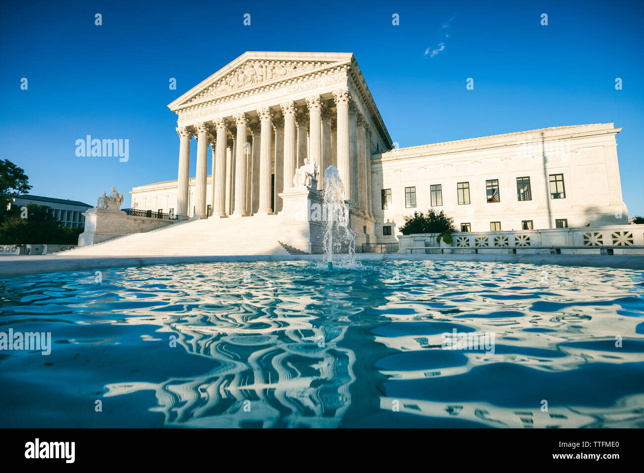 Luminose scenic sunny view del fronte esterno della Corte suprema degli Stati Uniti edificio con acque blu di una fontana in Washington, DC Foto Stock