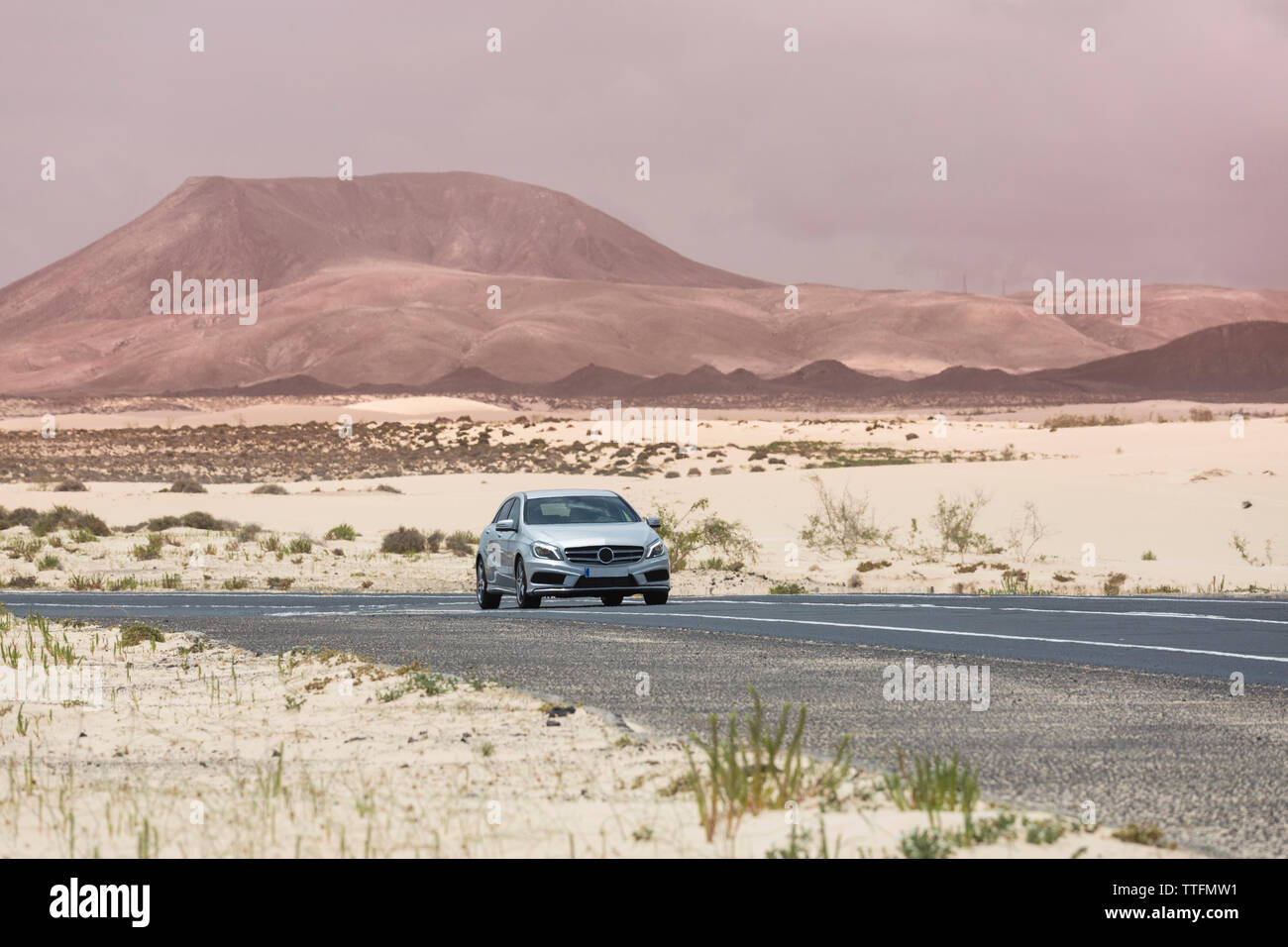 Grigio guida auto vuota strada asfaltata nel deserto paesaggio vulcanico Foto Stock