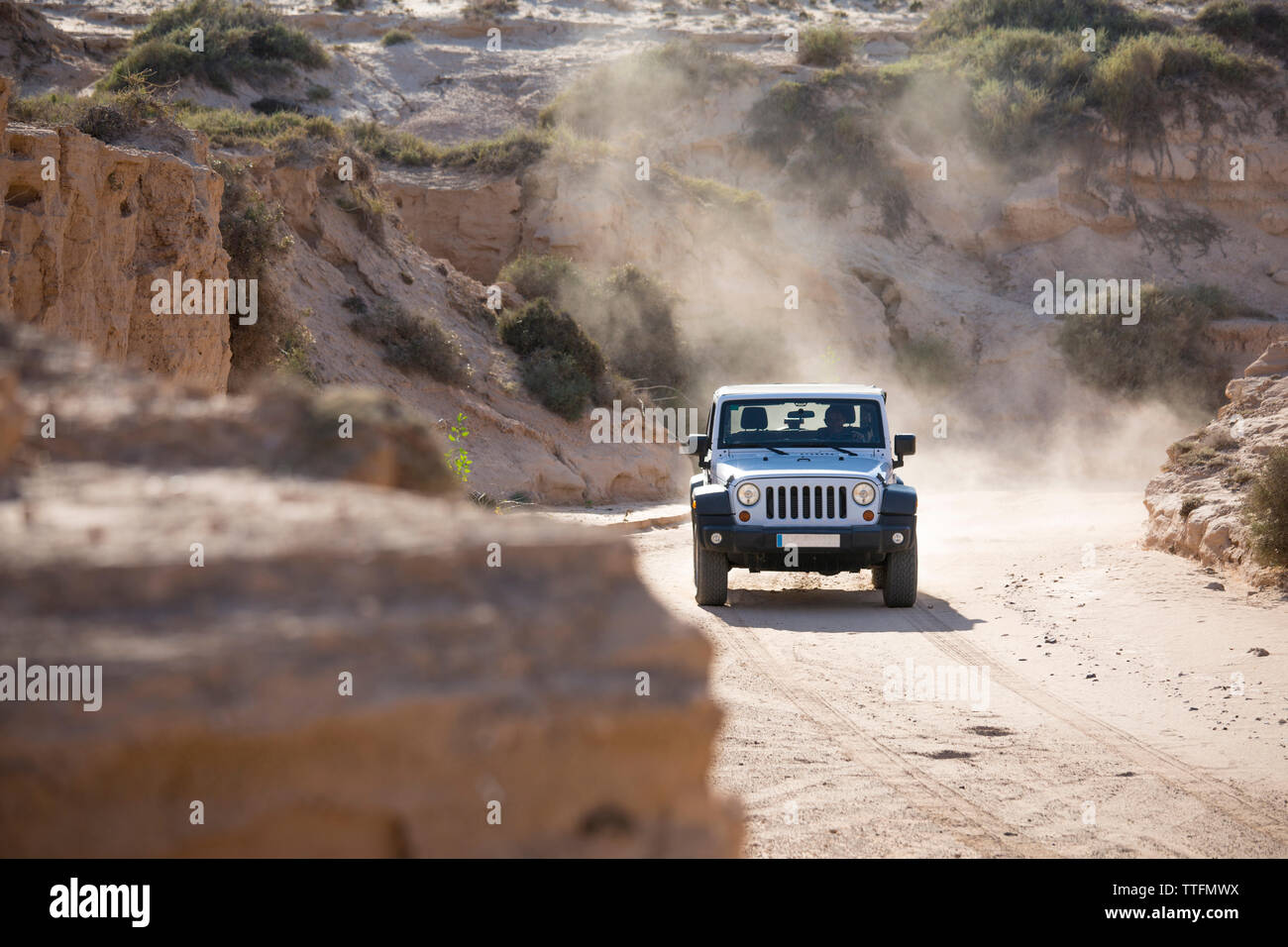Bianco jeep 4x4 guida fuori strada un vuoto polveroso e sabbiosa strada sporca Foto Stock