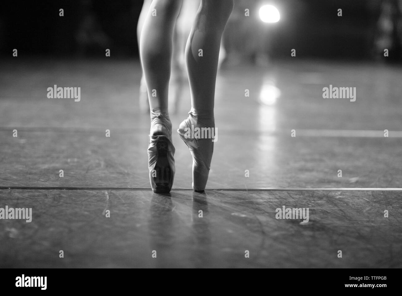 Eleganti gambe di una ballerina in piedi sul pointe sul palco durante una performance Foto Stock