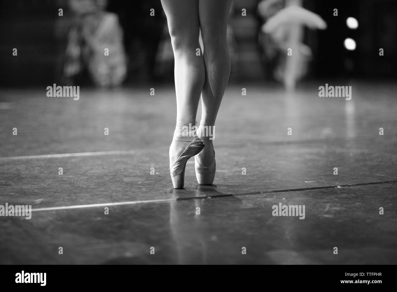 Eleganti gambe di una ballerina in piedi sul pointe sul palco durante una performance Foto Stock