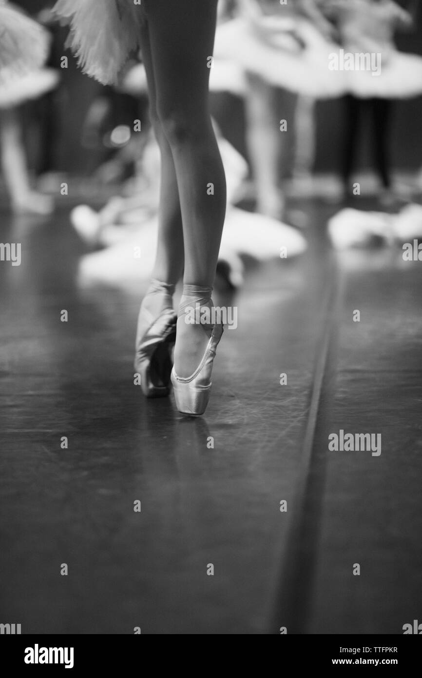 Eleganti gambe di una ballerina in piedi sul pointe sul palco durante la prova Foto Stock