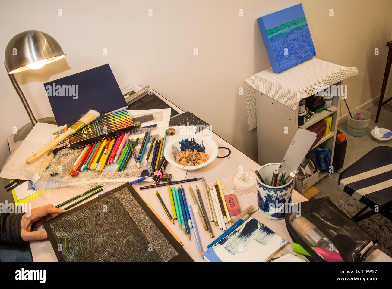 La parte superiore di una scrivania in un confuso art studio. Foto Stock