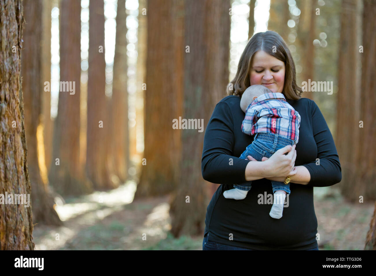 La Madre trattiene il figlio neonato in una impostazione di foresta Foto Stock