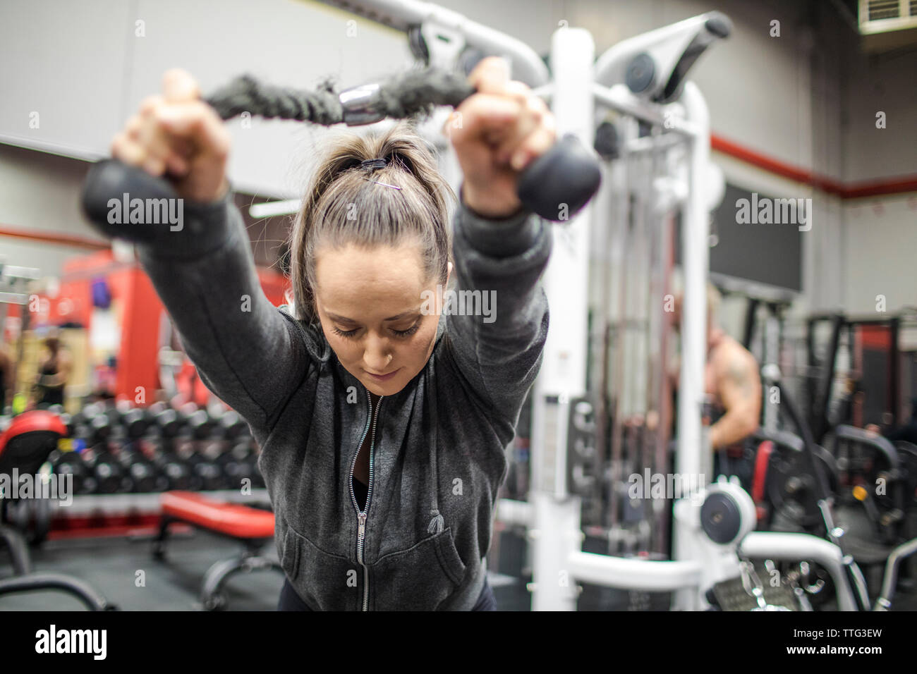 Montare la millenaria donna la sua formazione tricipiti in palestra Foto Stock