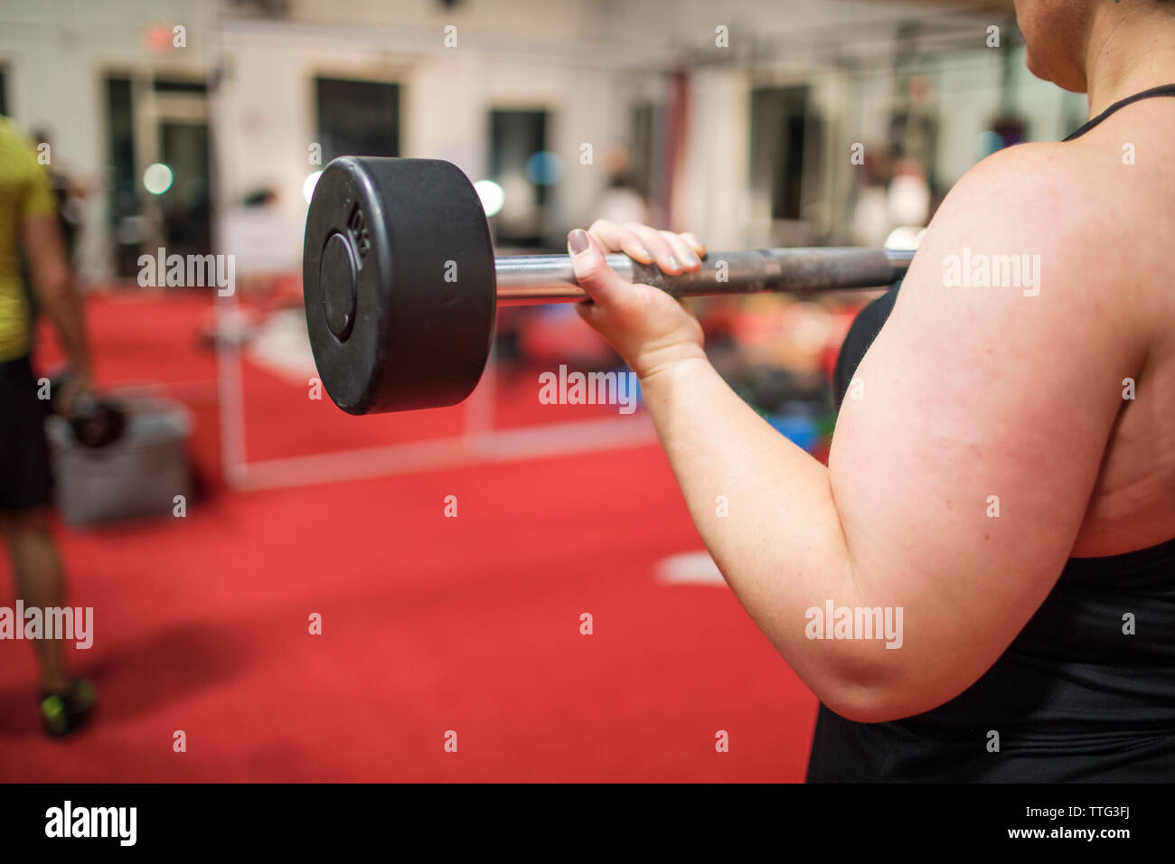 Dettaglio della donna forte formazione bicipite con riccioli in palestra. Foto Stock