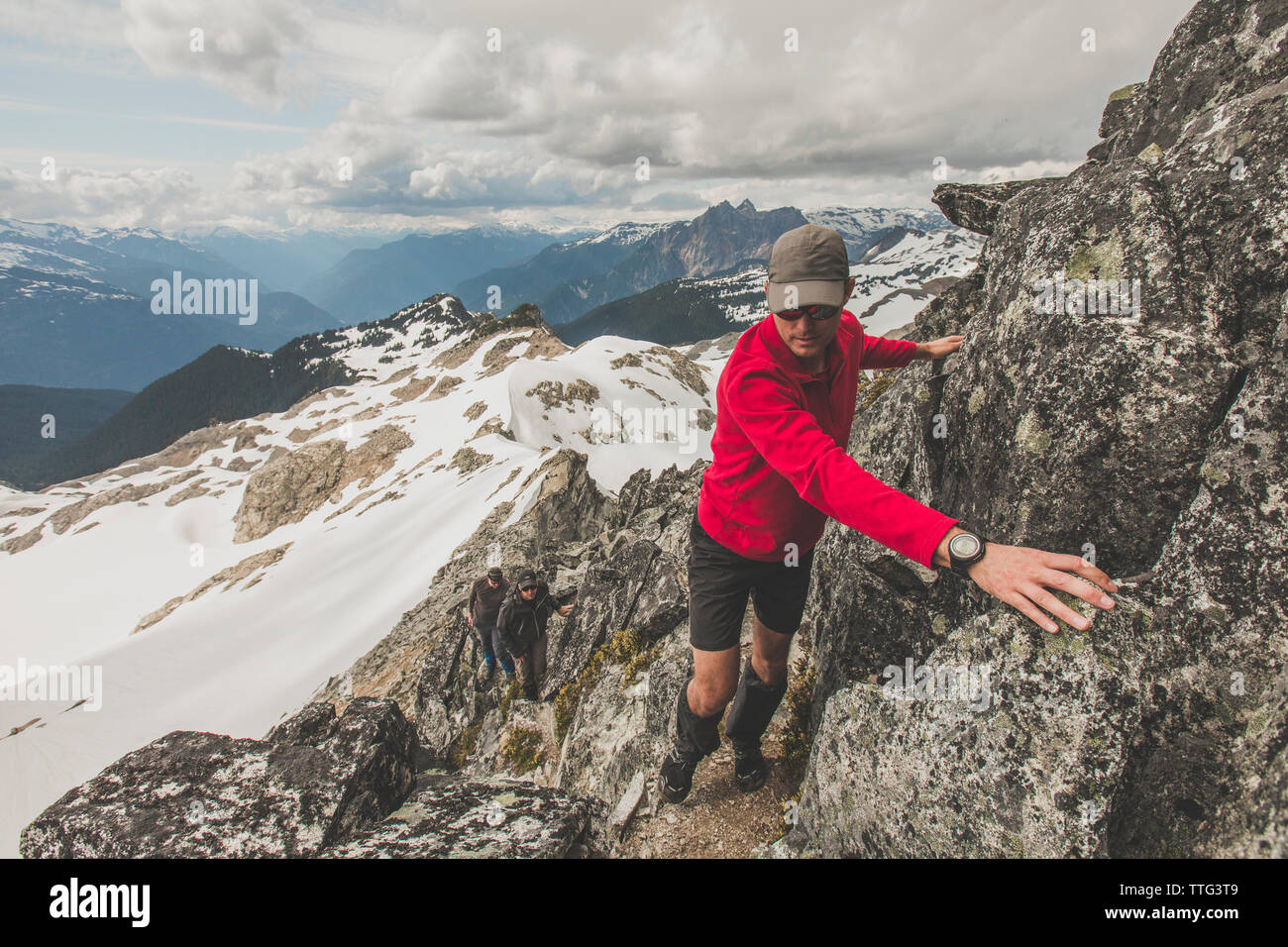 Tre uomini arrampicata Rocky Mountain ridge in British Columbia. Foto Stock