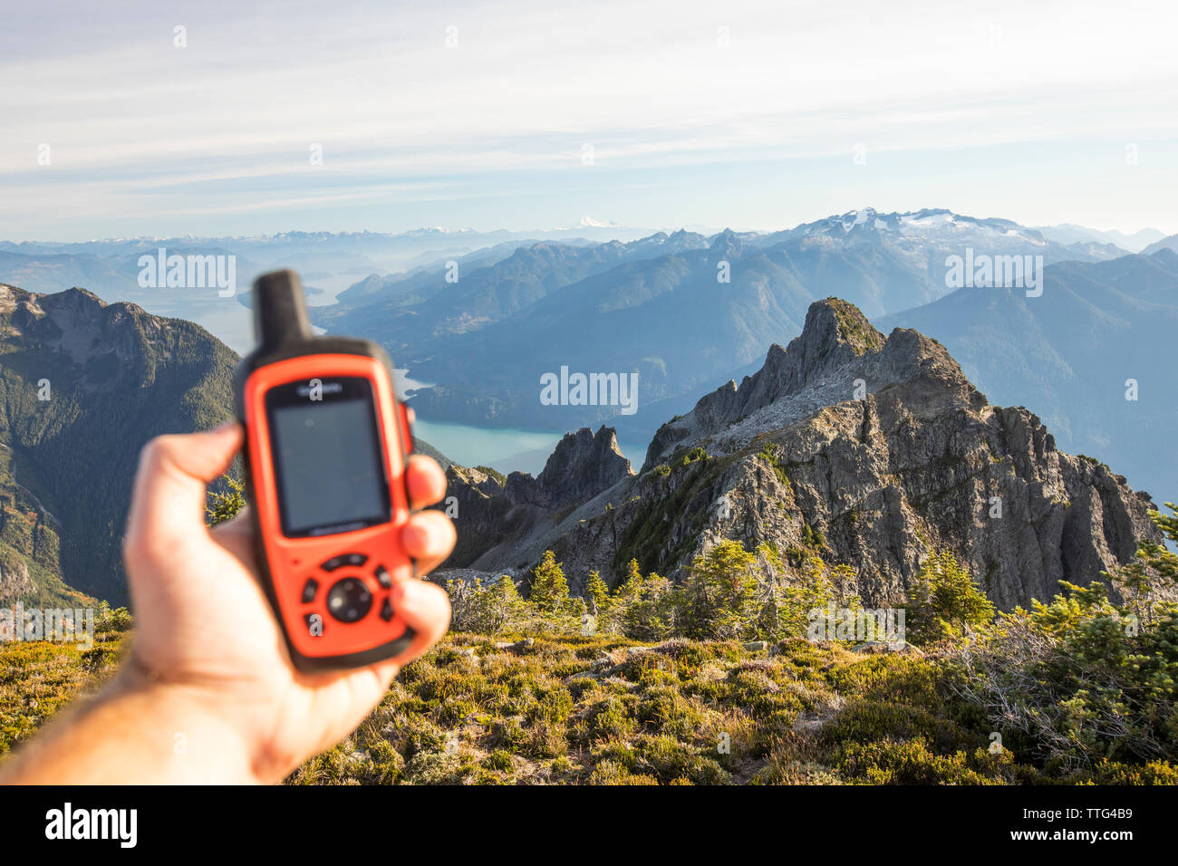 Escursionista utilizza il dispositivo GPS per navigare il percorso in avanti. Foto Stock