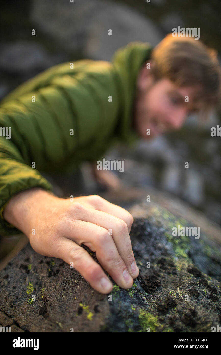 Elevato angolo di visione di un rocciatore di presa di una attesa con le sue dita Foto Stock