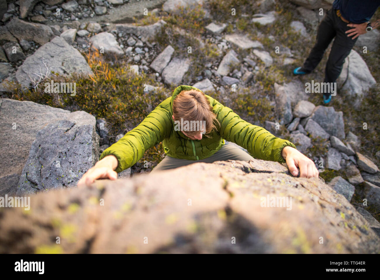Angolo di alta vista di uno scalatore iniziare un percorso bouldering all'esterno. Foto Stock