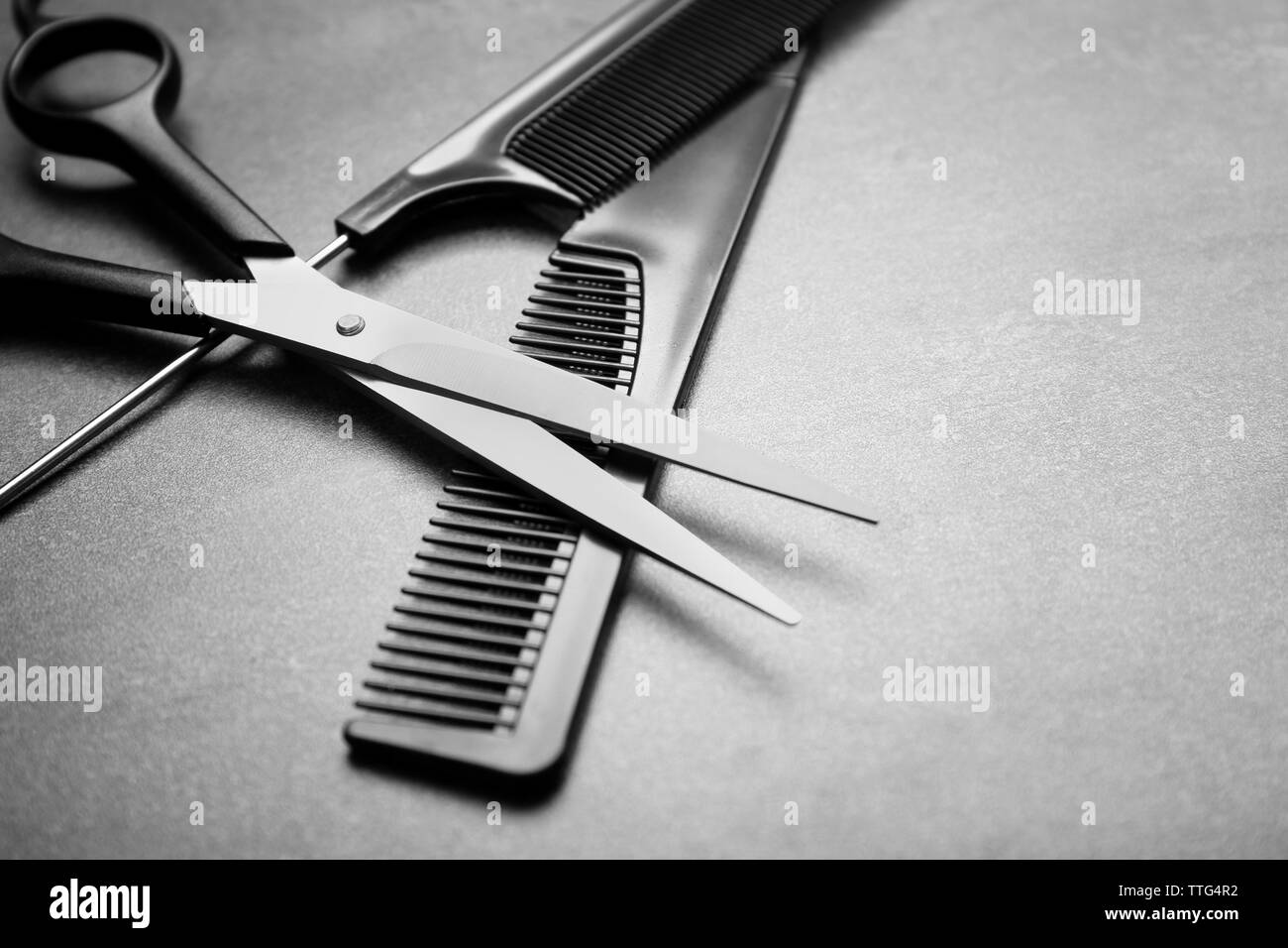 Set da barbiere con due pettini e forbici su sfondo grigio Foto Stock
