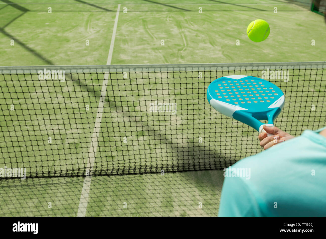 Sezione mediana della donna colpendo palla da tennis con la racchetta su corte Foto Stock